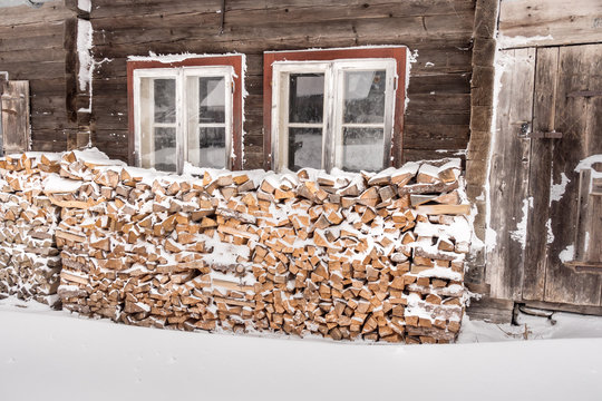 Feuerholz an der verschneiten Schih&uuml;tte