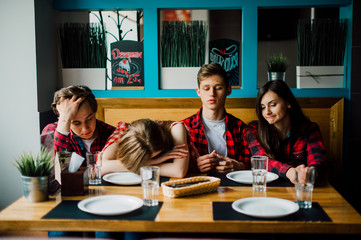 Group of young friends hanging out at a coffee shop. Young men and women meeting in a cafe having fun and drinking coffee. Lifestyle, friendship and urban life concepts.