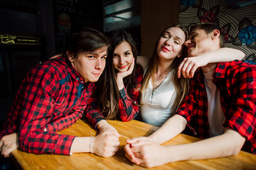 Group of young friends hanging out at a coffee shop. Young men and women meeting in a cafe having fun and drinking coffee. Lifestyle, friendship and urban life concepts.