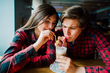 Group of young friends hanging out at a coffee shop. Young men and women meeting in a cafe having fun and drinking coffee. Lifestyle, friendship and urban life concepts.