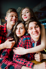 Group of young friends hanging out at a coffee shop. Young men and women meeting in a cafe having fun and drinking coffee. Lifestyle, friendship and urban life concepts.