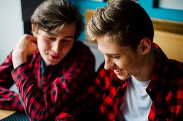 Group of young friends hanging out at a coffee shop. Young men and women meeting in a cafe having fun and drinking coffee. Lifestyle, friendship and urban life concepts.