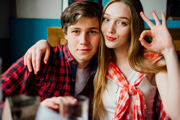 Group of young friends hanging out at a coffee shop. Young men and women meeting in a cafe having fun and drinking coffee. Lifestyle, friendship and urban life concepts.