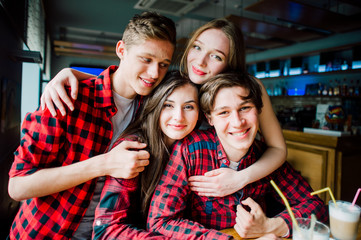Group of young friends hanging out at a coffee shop. Young men and women meeting in a cafe having fun and drinking coffee. Lifestyle, friendship and urban life concepts.