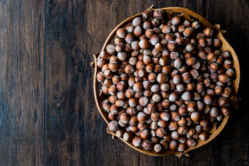 Stack of Hazelnuts in wooden bowl. Top view. Copy space.