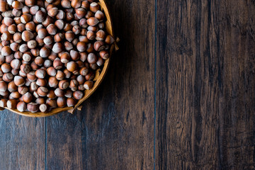 Stack of Hazelnuts in wooden bowl. Top view. Copy space.