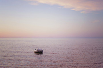 Naklejka premium Boat in the sea at sunset