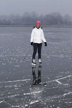 Young cheerful girl skating on the lake.