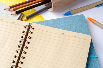 Blank daily planner notebook with pen and color pencils on white
