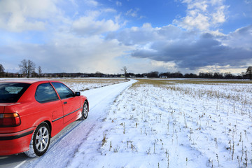 Samochód osobowy na polnej drodze zimą.