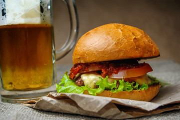 Homemade burger and a glass of beer on a craft paper
