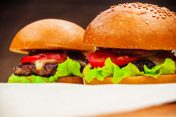 Two homemade burgers on a baking paper