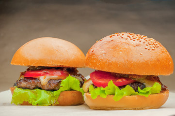 Two homemade burgers on a baking paper