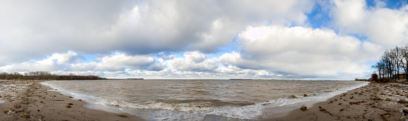 Fototapeta na wymiar Panorama Baltic sea beach after a storm with blue cloudy sky