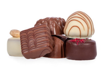 Gourmet bonbons, aka bon-bons and truffles made of dark, white and milk chocolate isolated on white background