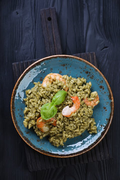 Plate with spinach risotto on a black wooden background
