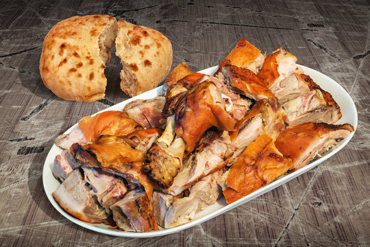 Spit Roasted Pork Shoulder Slices Served with Pitta Bread on Old Lacquered Cracked Wooden Garden Table