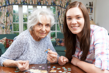 Teenage Granddaughter Doing Jigsaw Puzzle With Grandmother