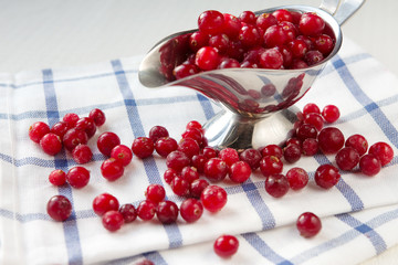 Cranberry and jar of jam on a light background