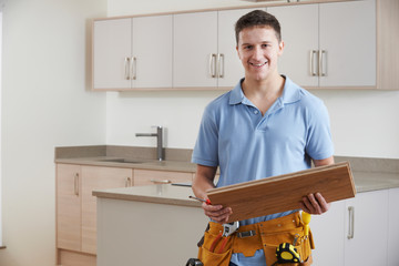 Portrait Of Carpenter Installing Fitted Kitchen