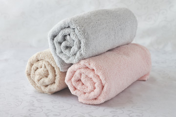 Fototapeta na wymiar Twisted bath towels on white background