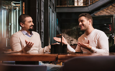 Delighted handsome men looking at each other