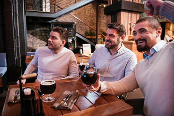 Positive cheerful men watching football