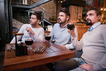 Serious pleasant men spending time in the pub