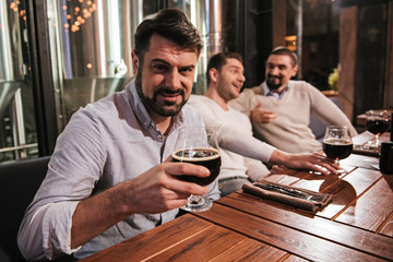 Handsome bearded man holding a glass with beer
