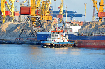 Tugboat assisting bulk cargo ship