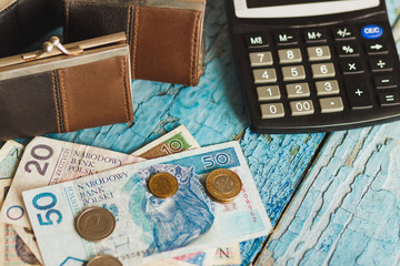 Polish zloty with a wallet and calculator, wooden background