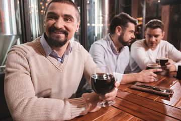 Handsome bearded man having beer with his friends