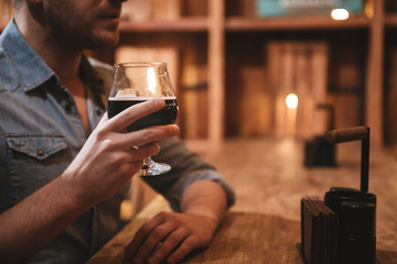 Glass with beer being held by a handsome nice man