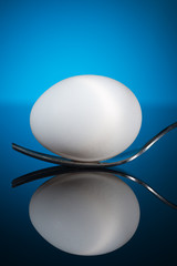 egg on a fork on a blue background
