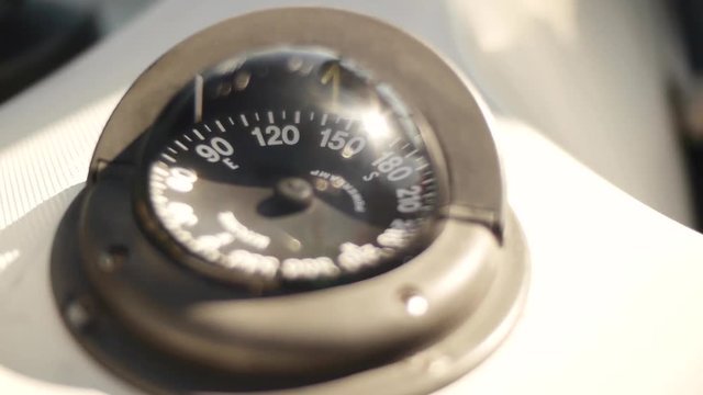 compass on a sailing boat giving direction in the summer sun