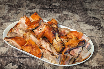Plateful of Spit Roasted Pork Shoulder Slices Set on Old Cracked Flaky Wooden Garden Table