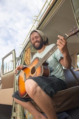 Man with guitar in combi van.