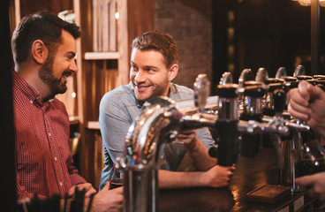 Handsome positive friends talking with each other