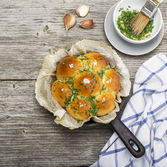 Fresh fragrant baked yeast rolls in the oven with herbs, dill, butter, salt and garlic. Top view