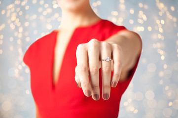 close up of woman showing hand and engagement ring