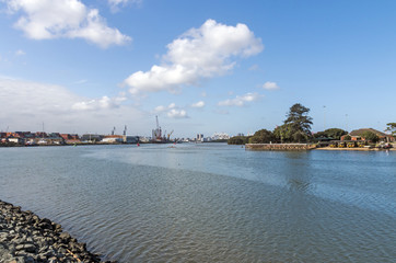 Fototapeta premium Ocean and Harbor and Blue Cloudy City Skyline