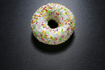 donut with colorful topping on black background