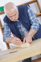 carpenter marking a wooden plank