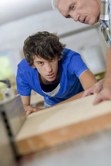 Two carpenters using a machine