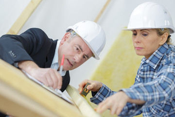 an architect and a female worker examining blueprints
