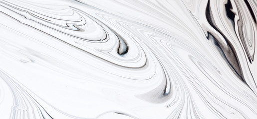 White and black paint mixing together creating shapes.