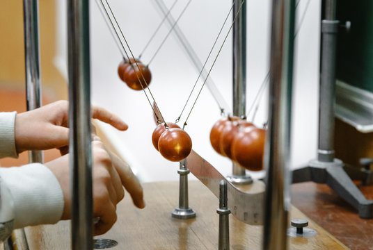 Experiment with balls in laboratory. Research concept. Conservation of energy. Simple Pendulums. When pendulum moving towards the mean position the potential energy is converted to kinetic energy.