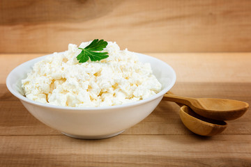 Fresh cottage cheese in a white bowl with spoon