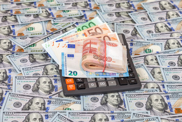 Folded stack of russian roubles, euro banknotes and calculator o