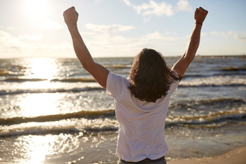 man with rised fist on beach